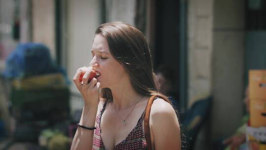 女人在街边吃水果