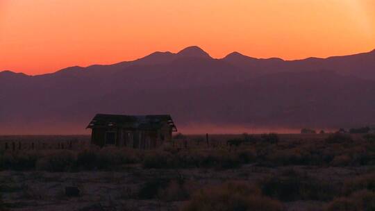 日落时平原上的小木屋