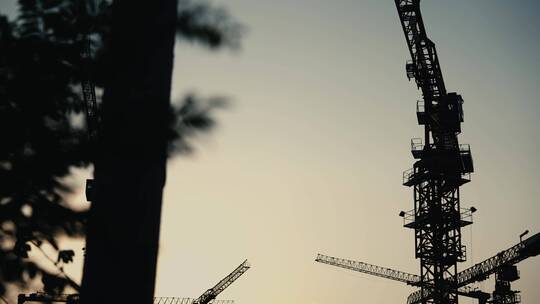 傍晚夕阳下的工地施工塔吊吊车