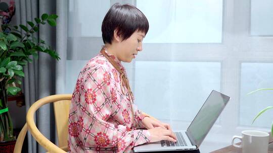 居家使用笔记本电脑办公的中国女性形象