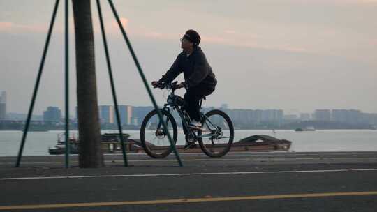 一个人在滨江公路上骑自行车欣赏美景