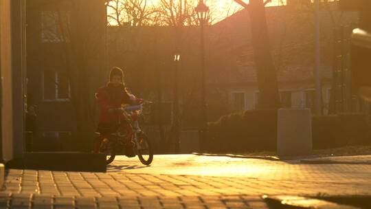 小女孩在夕阳中骑自行车