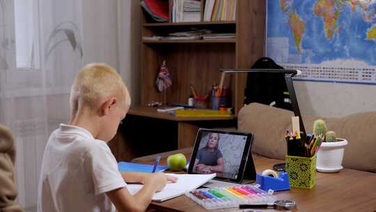 带平板电脑的男生与老师进行视频会议聊天