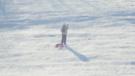 女孩拉着雪橇对着镜头挥手视频素材模板下载