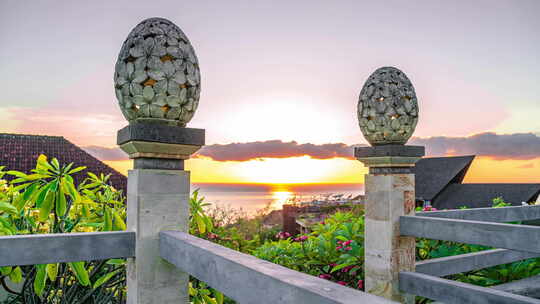 巴厘岛阿梅德海滩日出与海面背景下的灯笼花卉图案雕塑沙石