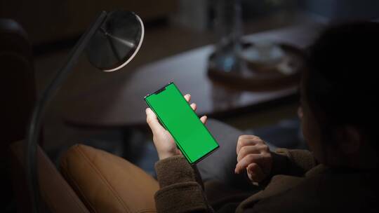 女性使用绿色绿幕抠像替换屏幕手机视频素材模板下载