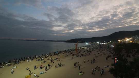 夕阳下的海边沙滩人群