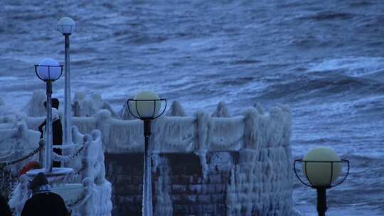 山东威海金海湾栈桥的冰海游客大浪狂风视频素材模板下载