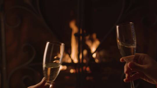 夫妇在壁炉前碰杯香槟
