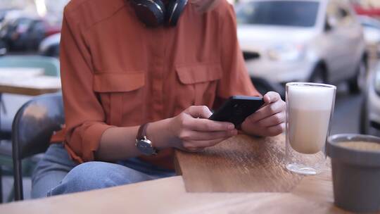 女人坐在咖啡馆玩手机视频素材模板下载