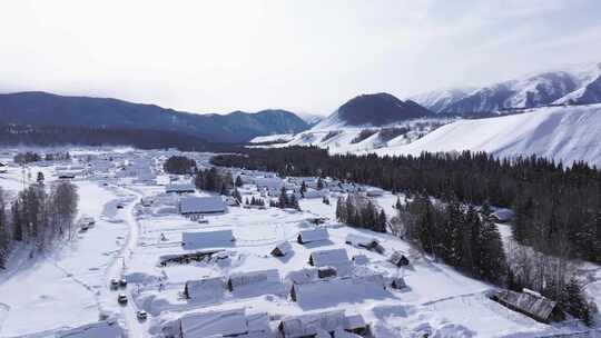 航拍新疆禾木雪景森林雪地小木屋禾木桥雪山