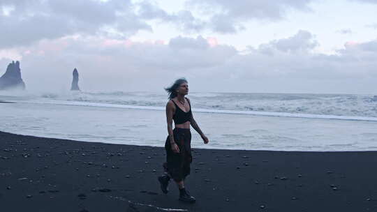酷女孩走在黑沙滩