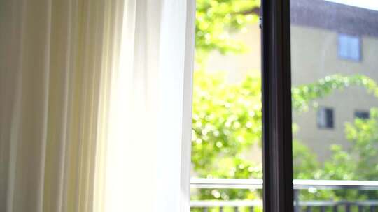 风吹窗帘窗户白色窗帘飘动阳光透过白色窗帘