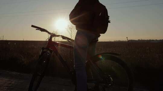 日落时分骑自行车的女人