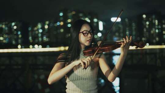 女子夜晚户外拉小提琴