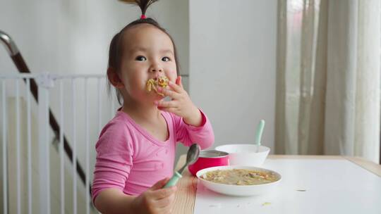 可爱小女孩在家自己吃饭