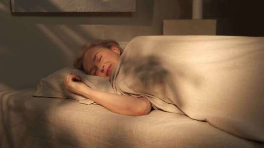 日出时，女人在床上醒来伸展身体视频素材模板下载