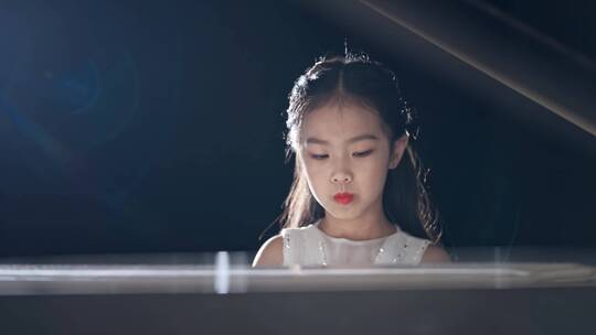 聚光灯下小女孩弹钢琴