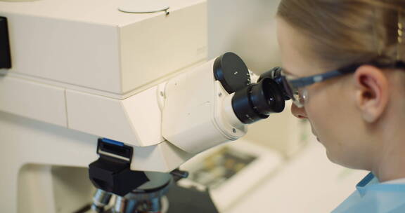 科学家在实验室里的显微镜下检查细菌