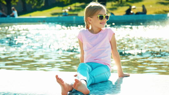 阳光下女孩坐在喷泉旁放松