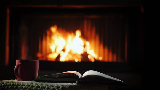 一本书和一杯冒着热气的咖啡在壁炉附近的桌子上