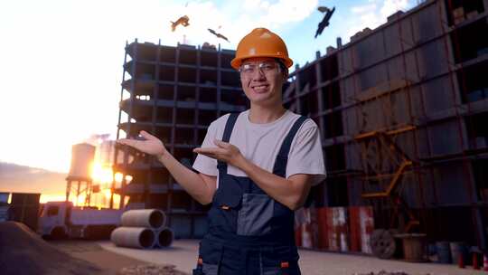 亚洲男子工人在建筑工地指向侧面