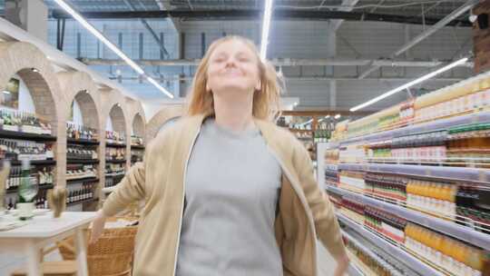 一个女人伸出双臂跑过超市的过道