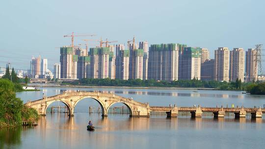 绍兴青甸湖古老石拱桥和远处的建筑工地