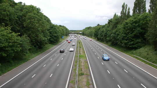 沿着英国M1高速公路行驶的汽车，两边都被