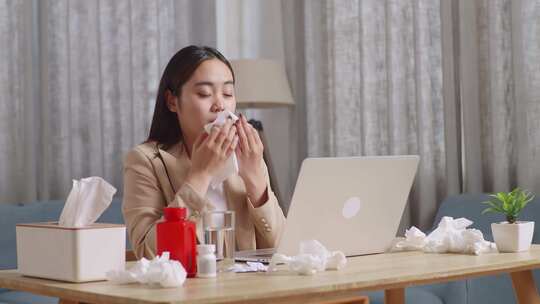 用笔记本电脑工作时生病的亚洲女商人。生病的女孩打喷嚏把鼻涕擦到组织里