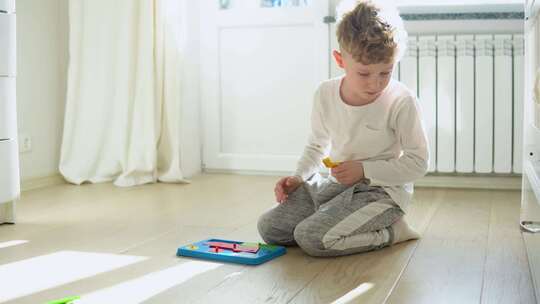 小男孩在托儿所的地板上玩教育玩具视频素材模板下载