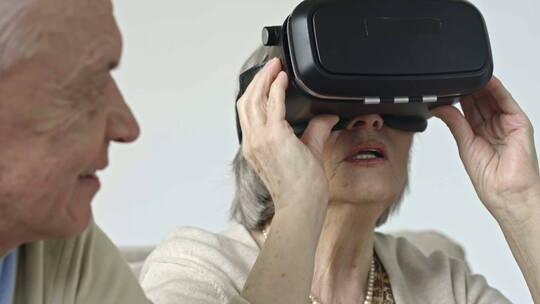 老年妇女尝试虚拟现实眼镜视频素材模板下载