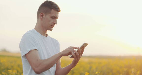 农民在油菜田里使用手机
