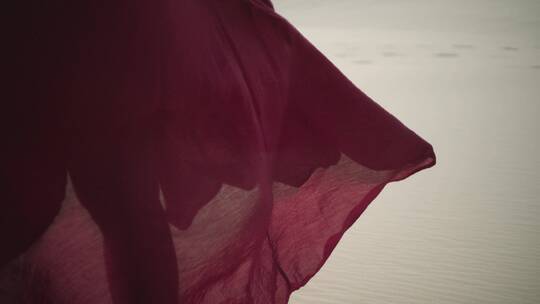 女人的红色裙摆在海边随风飘扬