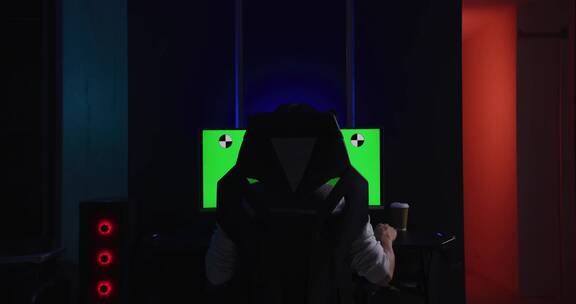 游戏玩家坐在绿屏凹形电脑屏幕前玩
