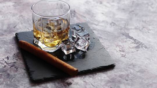 桌面上的雪茄和加冰块的威士忌