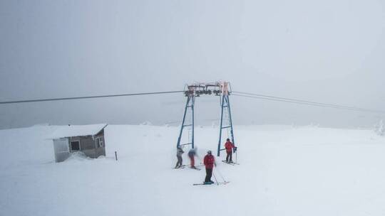 在雾蒙蒙的雪山上滑雪者视频素材模板下载