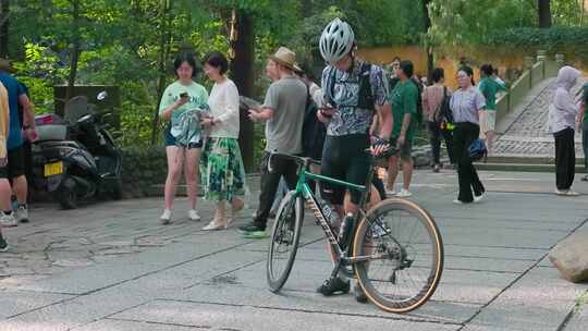 户外景点处戴头盔男子扶着自行车