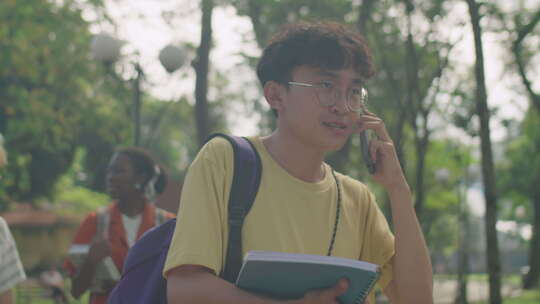 亚洲大学生在公园散步和打电话视频素材模板下载