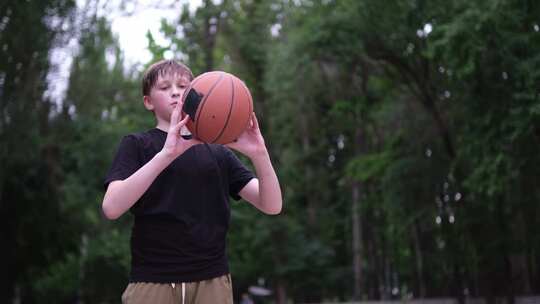 操场上专注的男孩训练篮球运动青少年男孩在