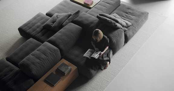 现代公寓里坐在舒适模块化沙发上的女人的俯