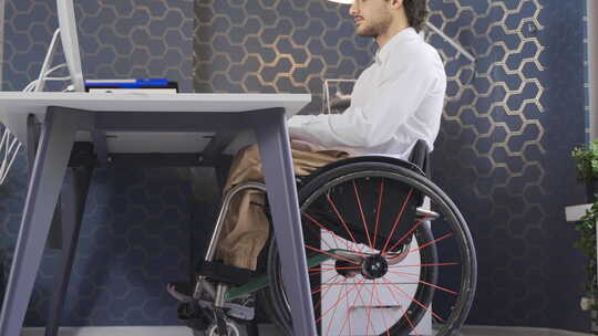 坐轮椅在办公室工作的残疾商人。