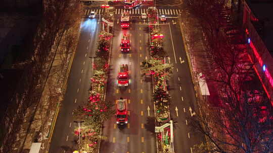 消防队消防车行驶在城市夜景街道上的航拍