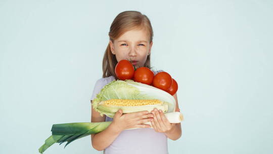 女孩抱着许多蔬菜对着摄像机笑视频素材模板下载