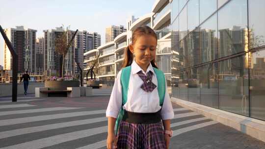 穿校服的小小学生在城市景观中上学