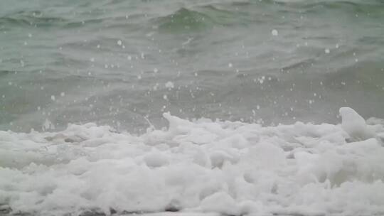 海浪冲击海滩溅起水花