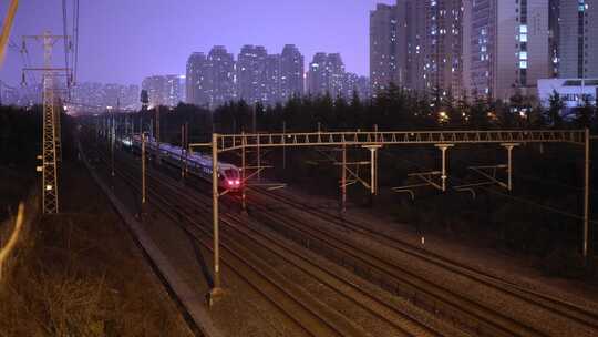 夜间高铁动车火车快速行驶火车穿过城市