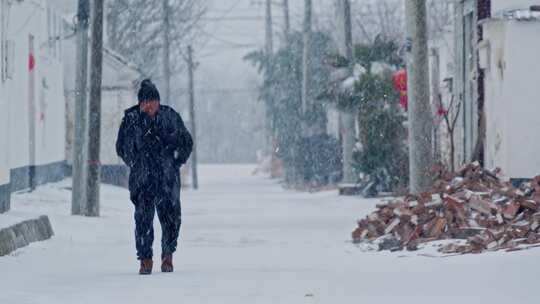 农村雪天走在路上的男人