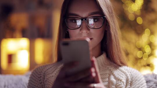 女人带着眼镜在玩手机