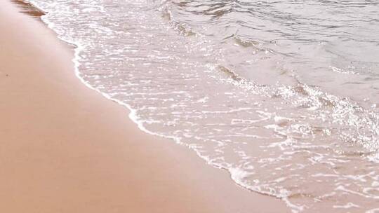 实拍海浪冲击着光滑的沙滩